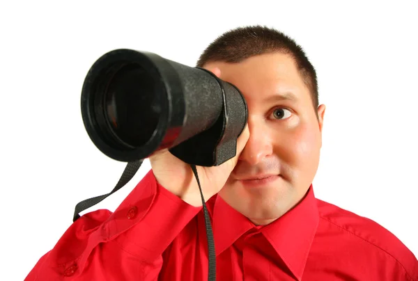 Businessman in red shirt looks in spyglass — Stock Photo, Image