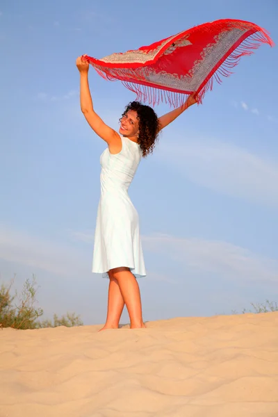 Meisje op zand met omslagdoek in handen — Stockfoto