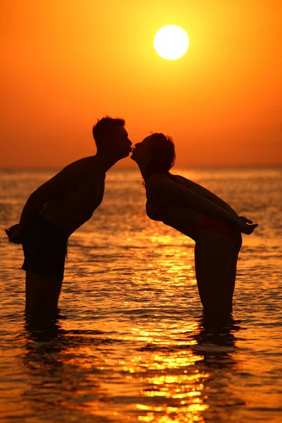 Couple kisses in sea on sunset — Stock Photo, Image