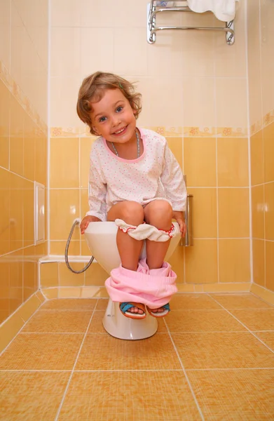 Dziewczynka siedzi na WC — Zdjęcie stockowe