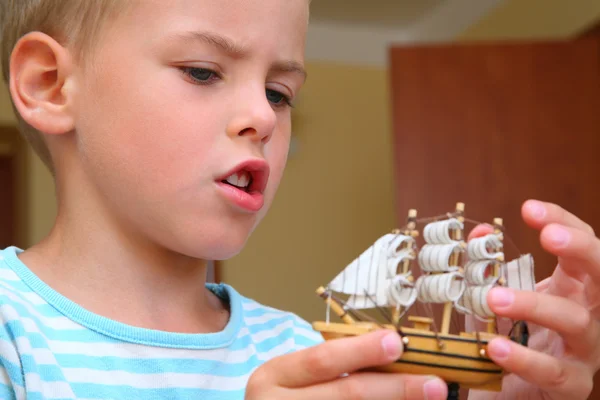 Мальчик с моделью корабля в руках — стоковое фото