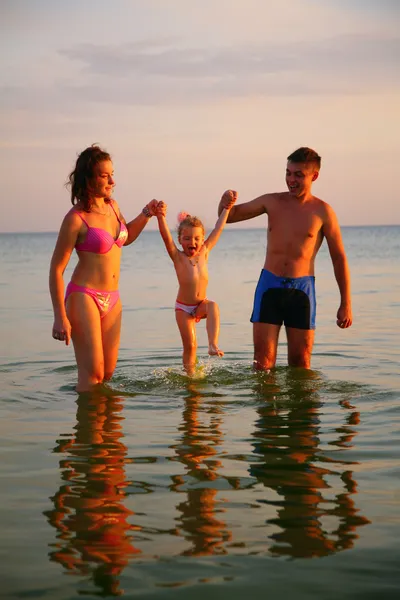Föräldrar hålla dotter från händer i havet — Stockfoto