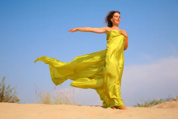 Young girl on sand in yellow shawl — Stock Photo, Image