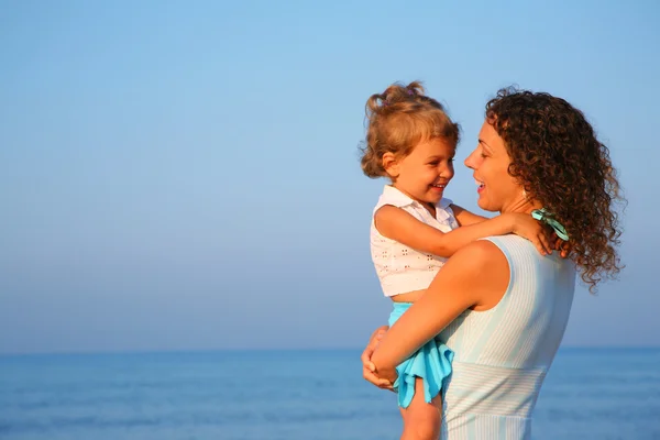 Mother keeps child at hands of edge of sea — Stock Photo, Image
