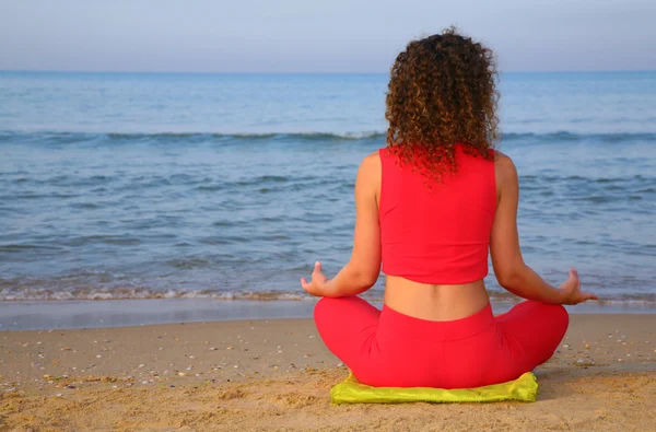 Девушка с йоги на пляже со спины — стоковое фото