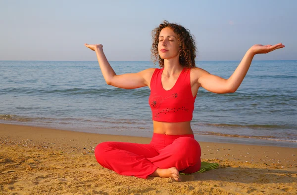 Девушка с йоги на пляже — стоковое фото