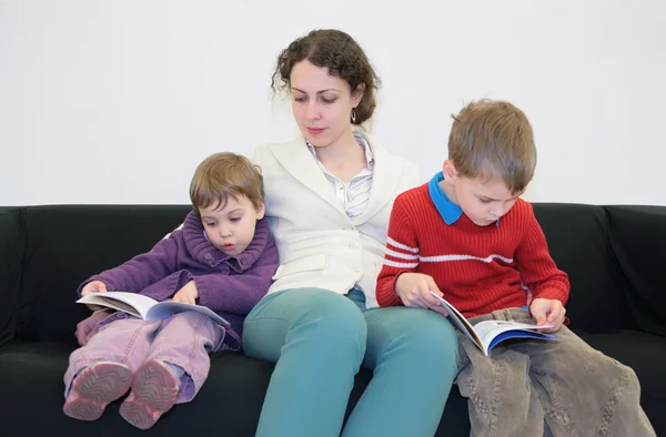 Dzieci z matka czytać książki na kanapie — Zdjęcie stockowe