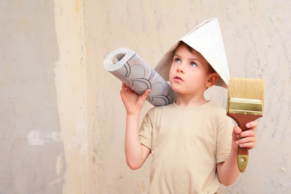 Chłopiec z pędzlem i rolki tapety w kapelusz papryka — Zdjęcie stockowe