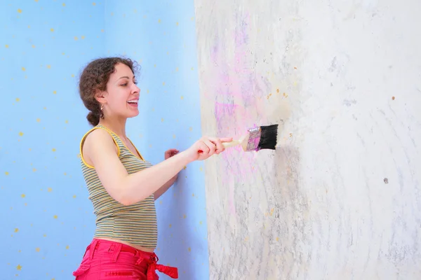 Mujer joven pega papel pintado —  Fotos de Stock