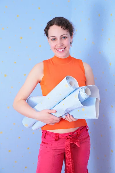 Девушка с рулонами настенной бумаги — стоковое фото