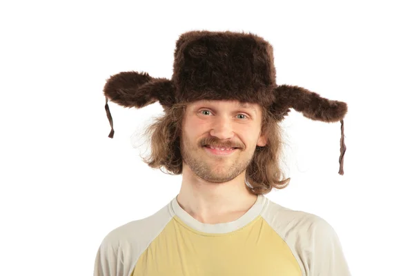Homme russe souriant aux cheveux longs en casquette avec des oreillettes — Photo