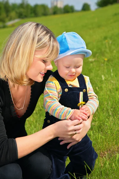 Mother with child and dandelion on meadow — Stock Photo, Image