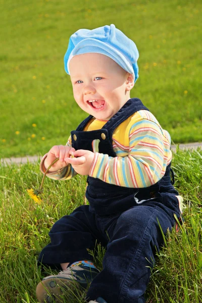 Дитина з кульбабою на лузі — стокове фото