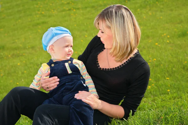 Mother and child sit on meadow — Stock Photo, Image