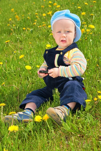 Child sits on grass — Stock Photo, Image