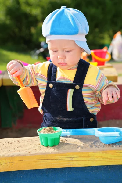 Little boy plays in sandbox — Stock Photo, Image