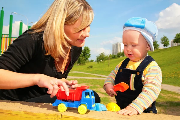 Mãe brinca com criança com carro de brinquedo — Fotografia de Stock