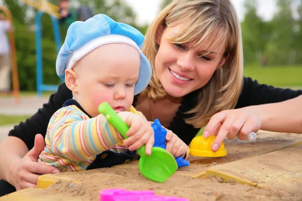 Mãe e criança brincam em sandbox — Fotografia de Stock