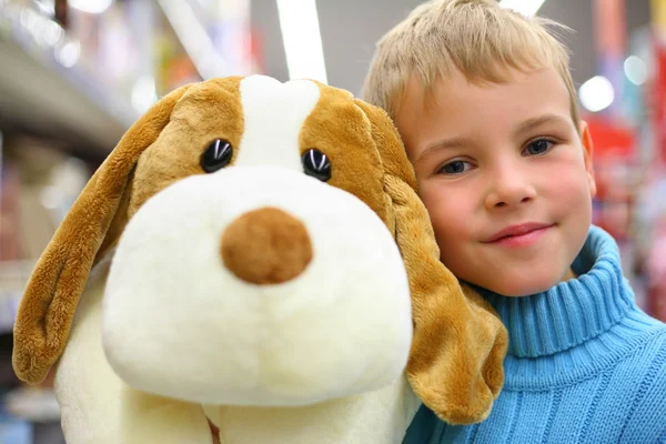 Хлопчик з іграшковою собакою в магазині — стокове фото