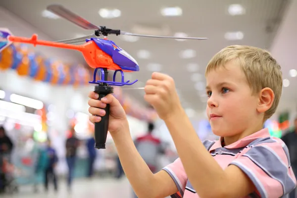 Мальчик в магазине с игрушечным вертолетом — стоковое фото