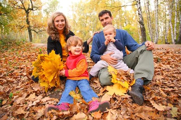 Family with yellow maple leaves in wood in autumn — Stock Photo, Image