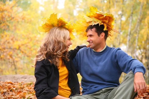 Пара с кленовыми листьями в осеннем лесу — стоковое фото