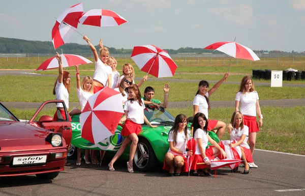 Девушки с зонтиками на гоночной трассе — стоковое фото