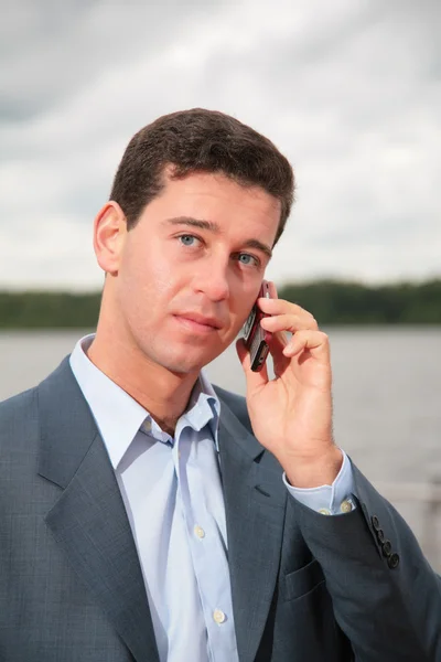 Retrato de homem perto da lagoa, que fala no celular — Fotografia de Stock