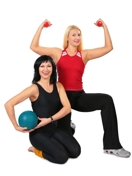 Две спортивные женщины с мячом и гантелями — стоковое фото