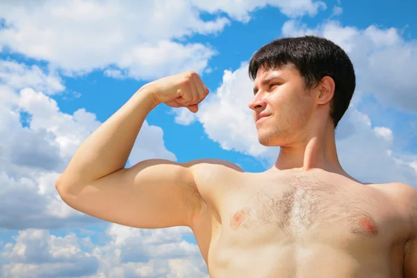 Bodybuilder på himmel bakgrund — Stockfoto