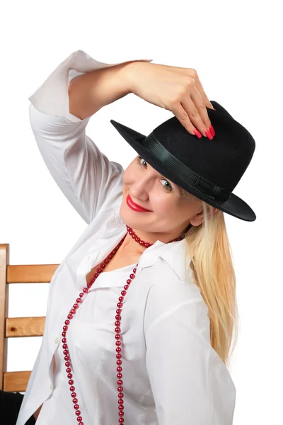Mooie blonde in zwarte hoed zit op stoel — Stockfoto