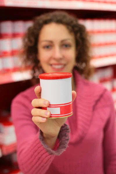 Young woman holds jar in food store — Stock Photo, Image