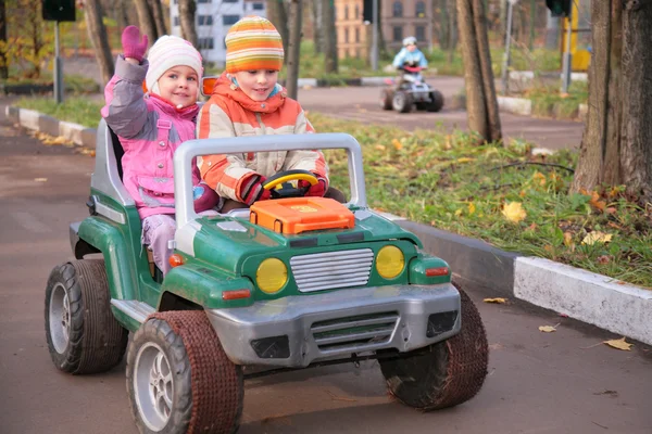Kinderen in speelgoedauto — Stockfoto
