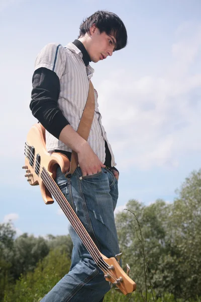 Young man with guitar on grass — Stock Photo, Image