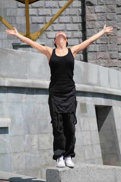Güzel esmer kaldırdı elleriyle blok taş üzerinde duruyor. — Stok fotoğraf