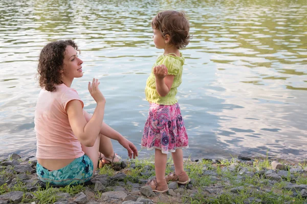 Mother with daughter near water — Stockfoto