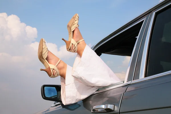 Female feet in window of car — Stock Photo, Image