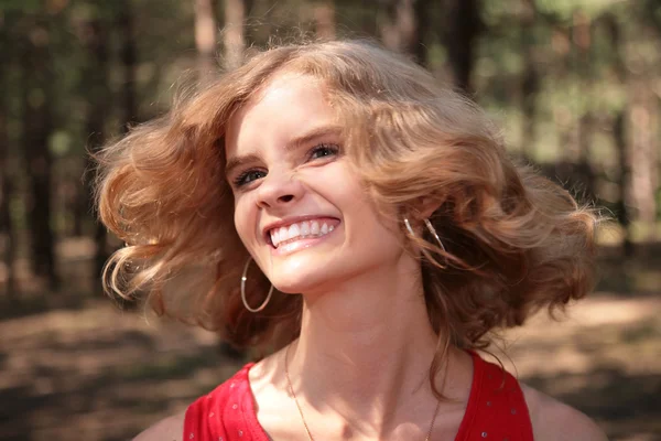 Młoda blondynka uśmiechający się w drewno — Zdjęcie stockowe