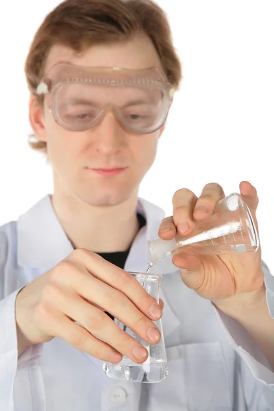Chemist pours liquid from one flask in another — Stock Photo, Image