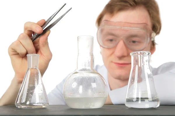 Chemist with tweezers and three flasks — Stock Photo, Image