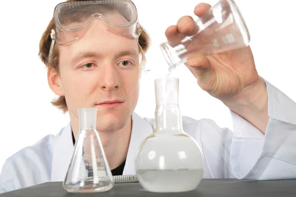 Chemist pours liquid in flask — Stock Photo, Image