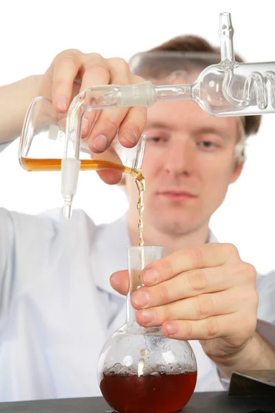 Chemist pours brown liquid in flask — Stock Photo, Image