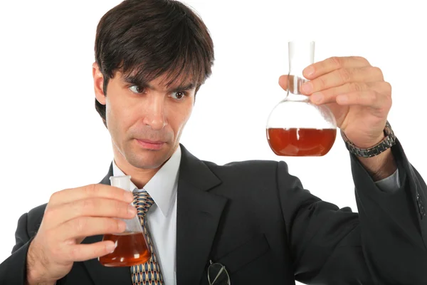 Vetenskapsman med två kolvar med brun vätska — Stockfoto