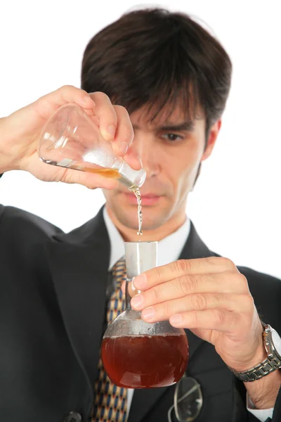 Scientist pours liquid from one flask in anothe — Stock Photo, Image
