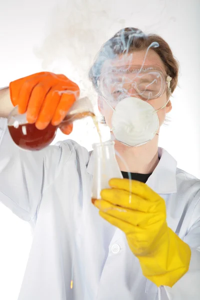 Chemist in smoke pours a liquid in a flask — Stock Photo, Image