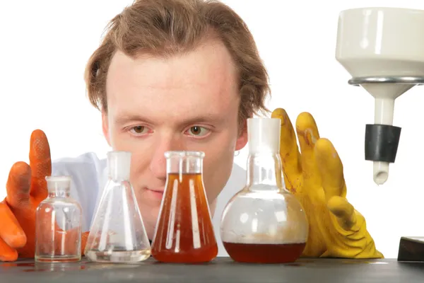 Χημικός κοιτάζει σε φιάλες με υγρά — Φωτογραφία Αρχείου