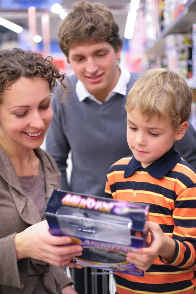 Pojke med föräldrar med leksak i butik — Stockfoto