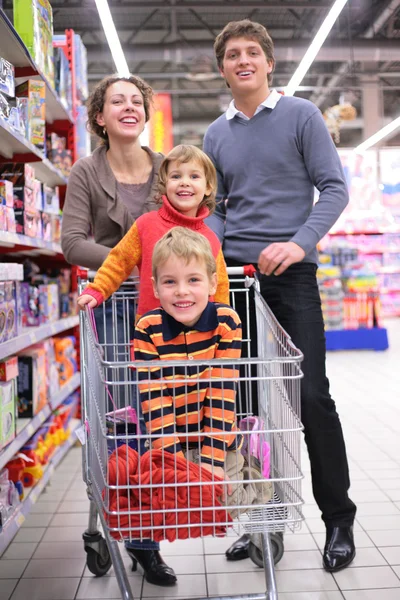 Pais com filhos no carrinho na loja — Fotografia de Stock