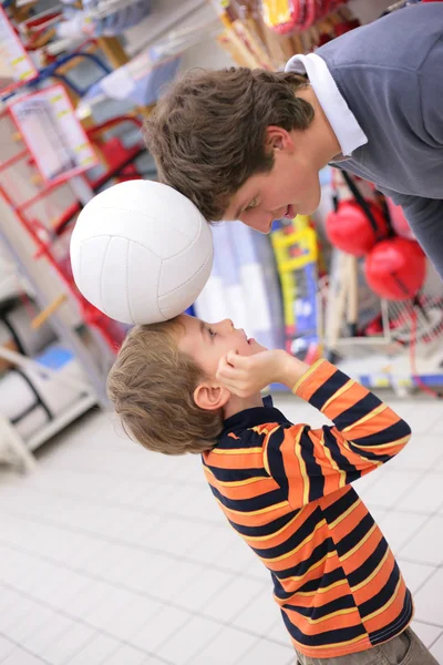 Отец с сыном и мячом в магазине — стоковое фото
