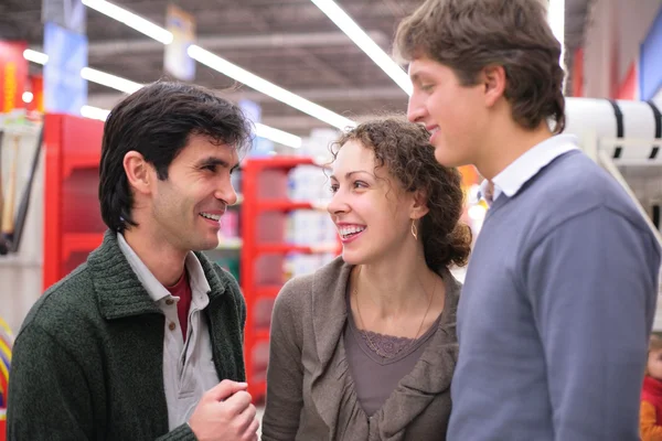 Трое друзей разговаривают в магазине — стоковое фото